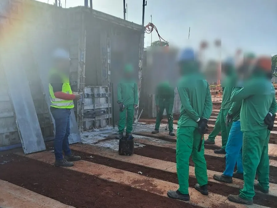 Treinamento orientativo em campo: equipe reunida na frente das fôrmas